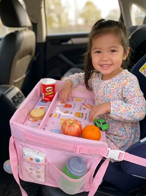 Young girl in a car seat using the pink Little Rider Travel Tray